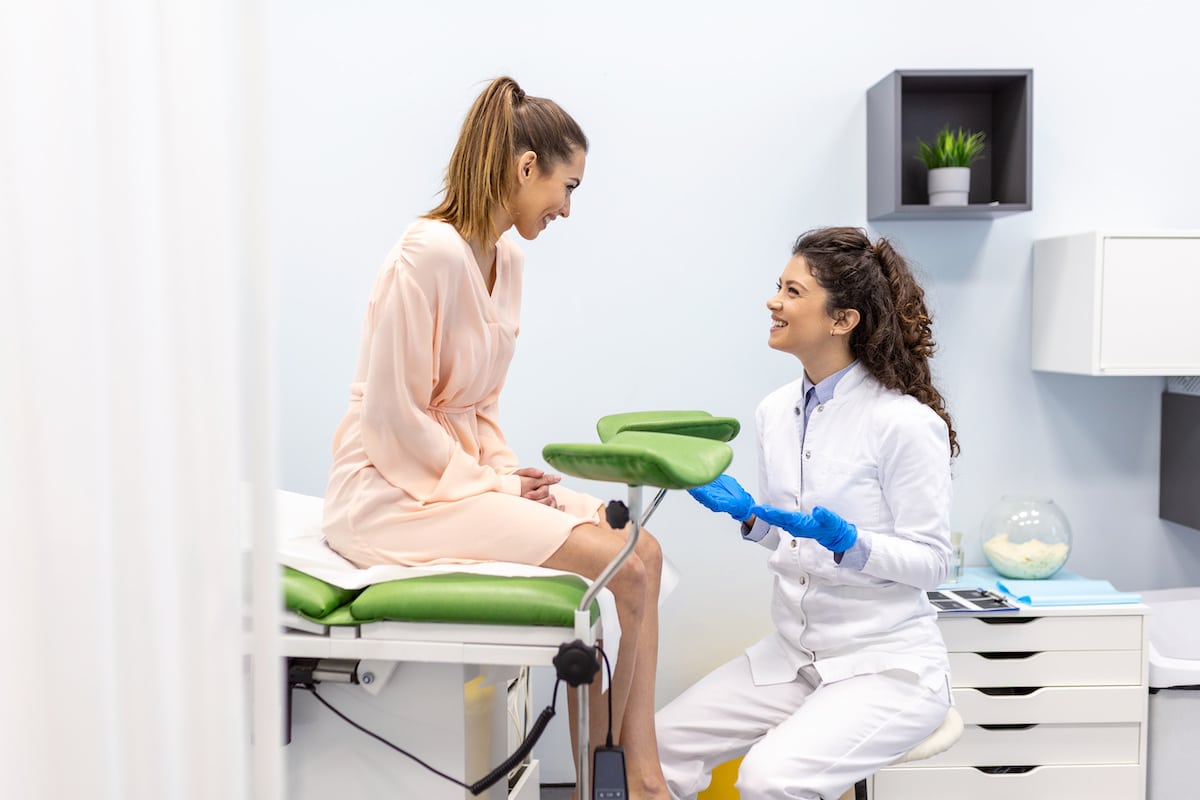 Gynecologist talking with young female patient during medical consultation in a Healthy Connections clinic.