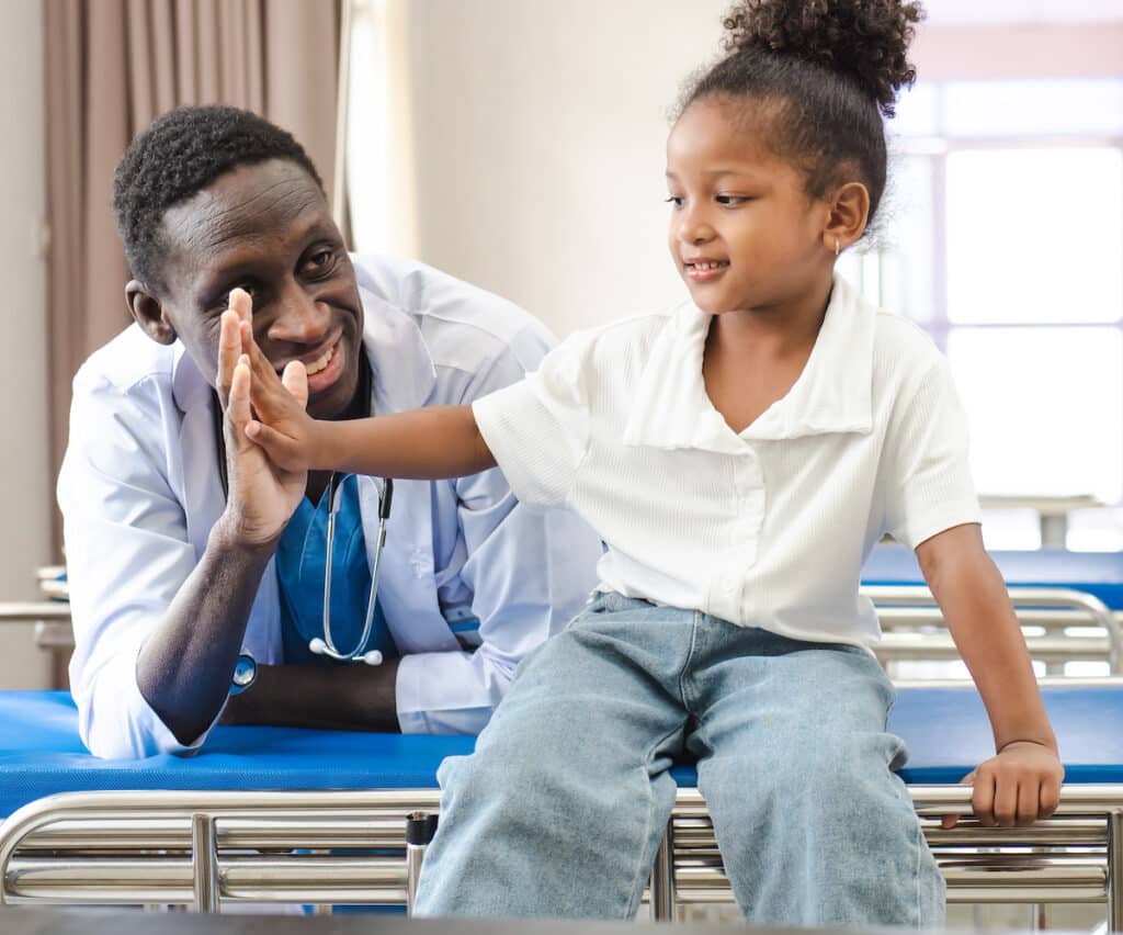 A doctor giving a high-five to a patient after receiving wound care.