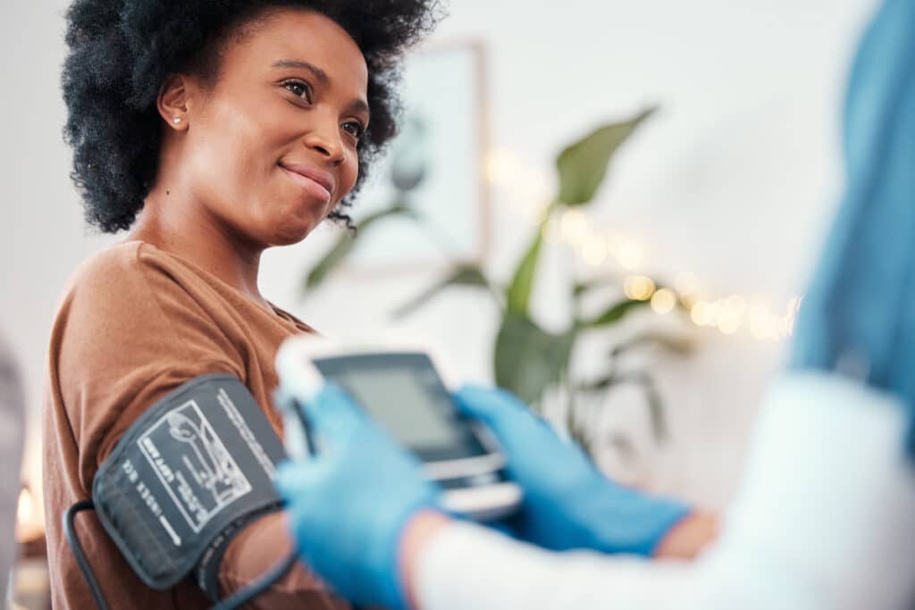 A black woman getting her blood pressure taken. Women's Health services at Healthy Connections