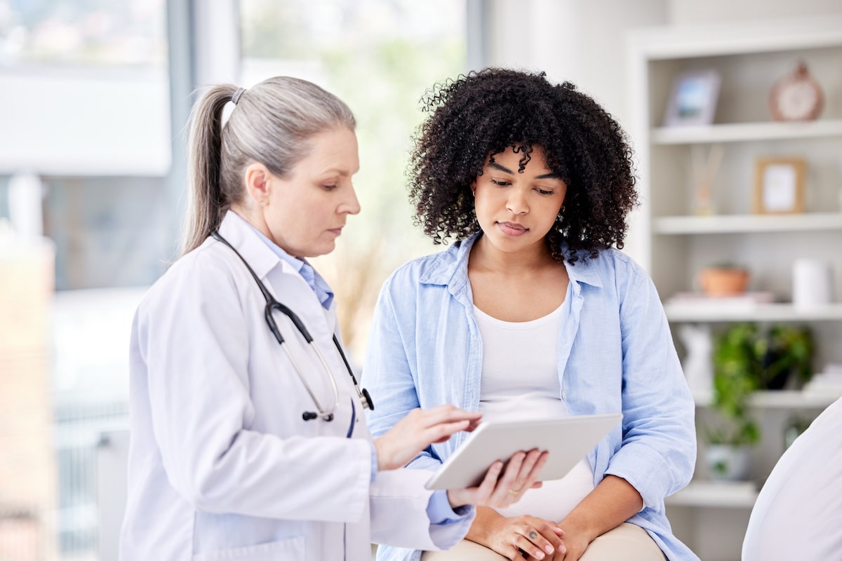 A woman discussing treatment plans with her primary care doctor in an office.