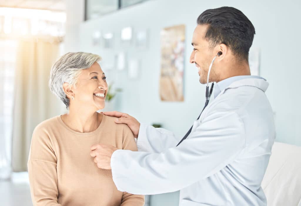 A doctor in cardiology checks a patient's heartbeat with a stethoscope.