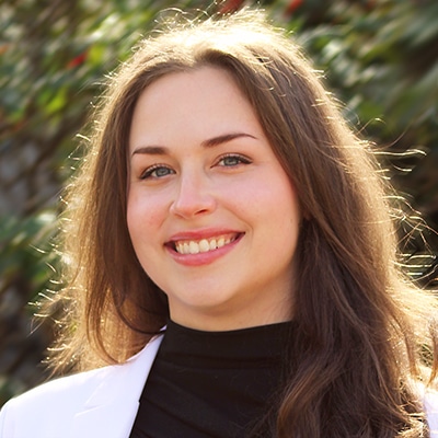 Taylor Watt, PharmD, professional headshot in her lab coat